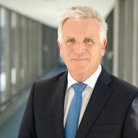 Thomas Ring in grauem Anzug mit blauer Krawatte