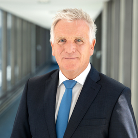 Thomas Ring, mit dunkelblauem Anzug und hellblauer Krawatte